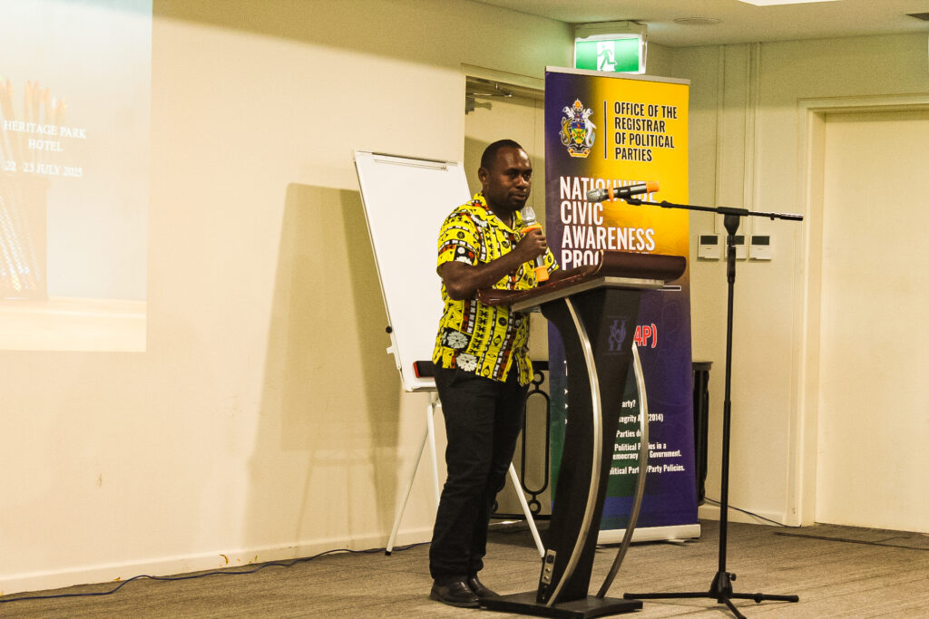 Presenter speaking at a podium during a civic awareness workshop.